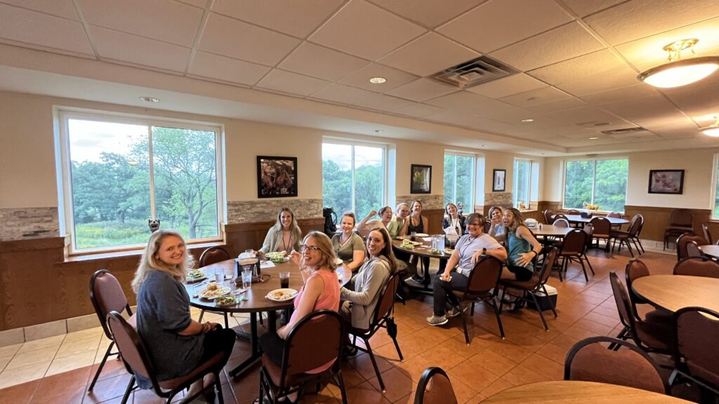 2 tables of therapists enjoying a meal together at the retreat center for the Grounded to Grow nature based therapy retreat