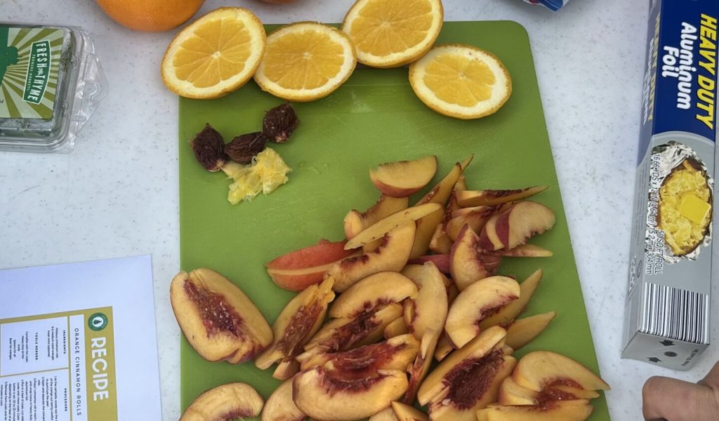 cut up citrus and peaches for open fire cooking at the nature based therapist retreat